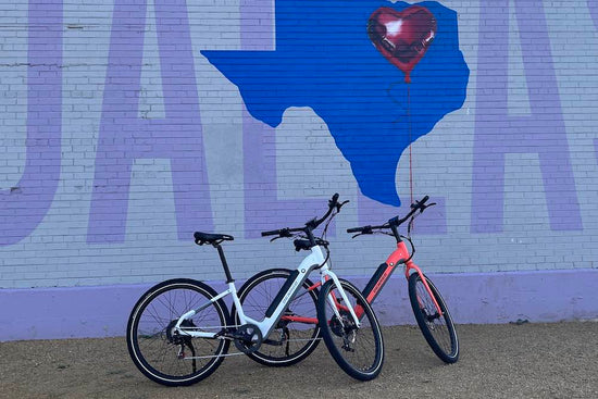 2 Denago eBikes in front of a Texas mural