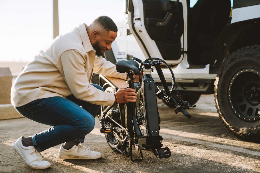 Photo of a man folding a Denago eBike at the beach