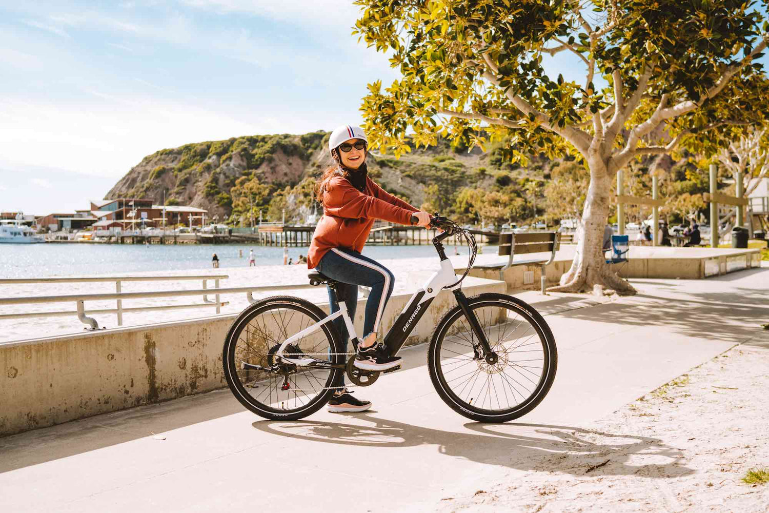 Woman with an eBike in front of the harbor