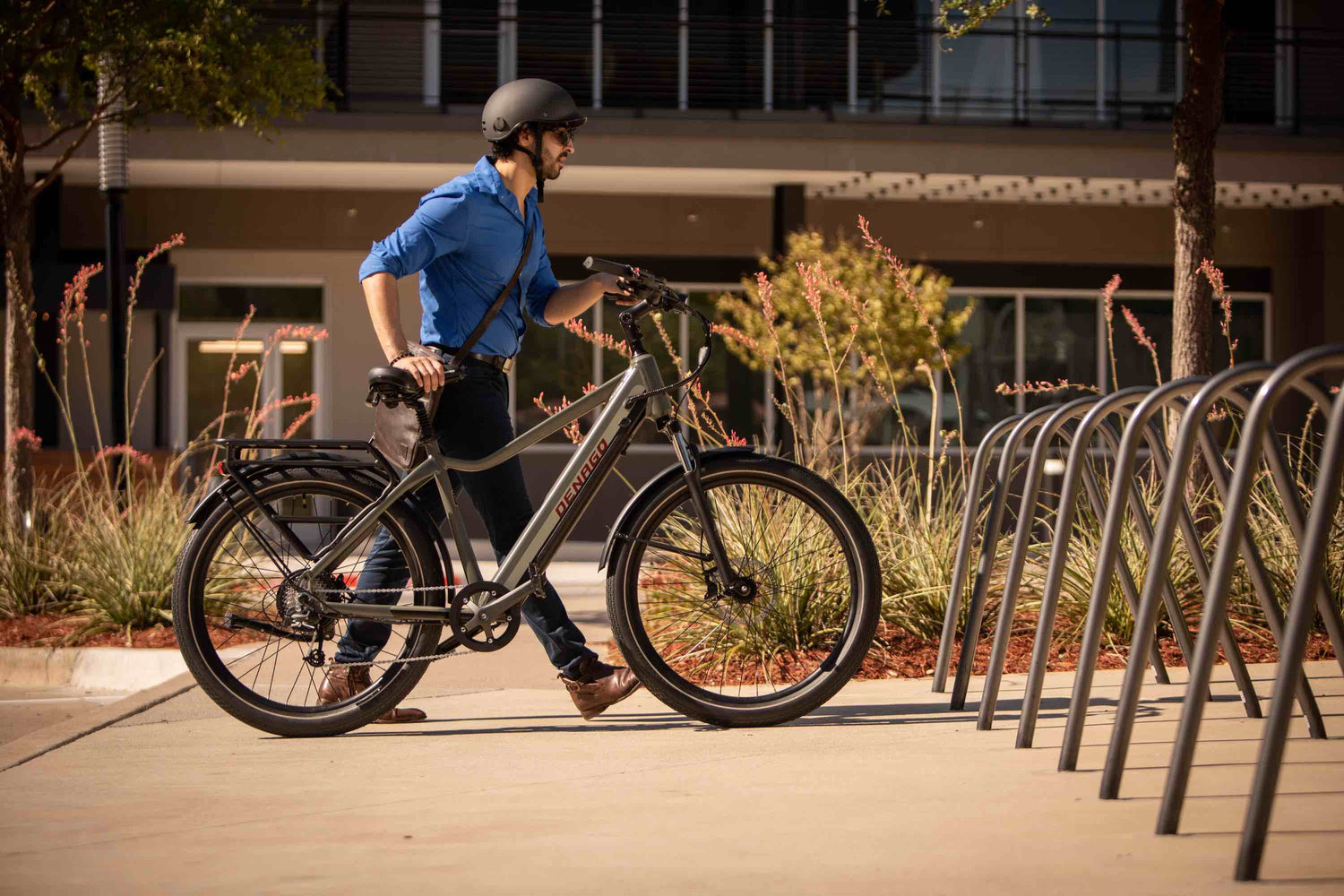Man putting a Denago eBike into a bike rack