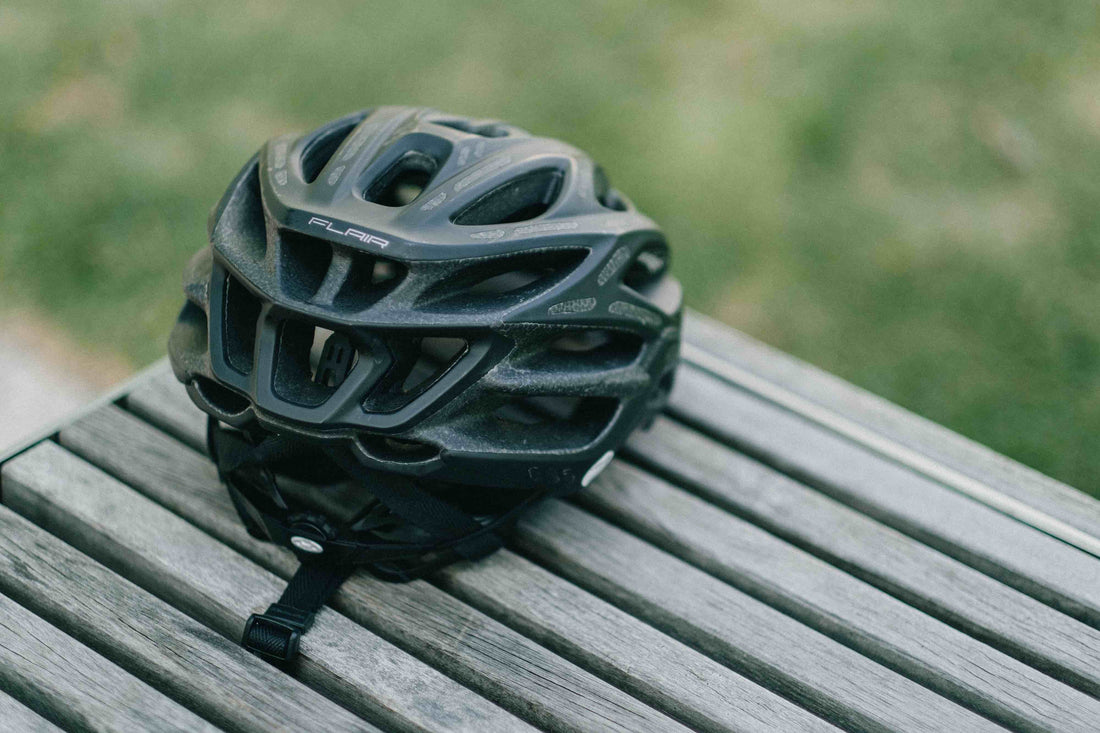 photograph of a black bicycle helmet on a picnic bench