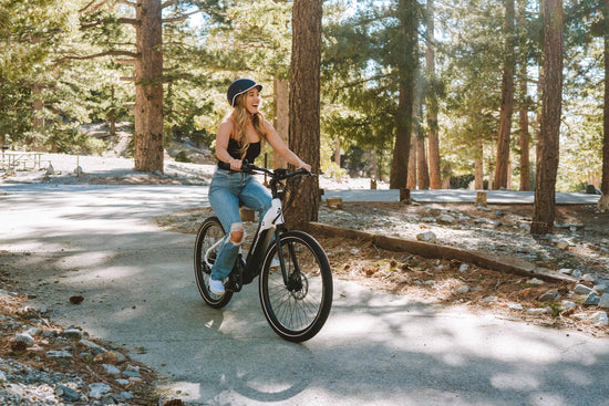 Photograph of a woman riding a Denago eBike in the forest