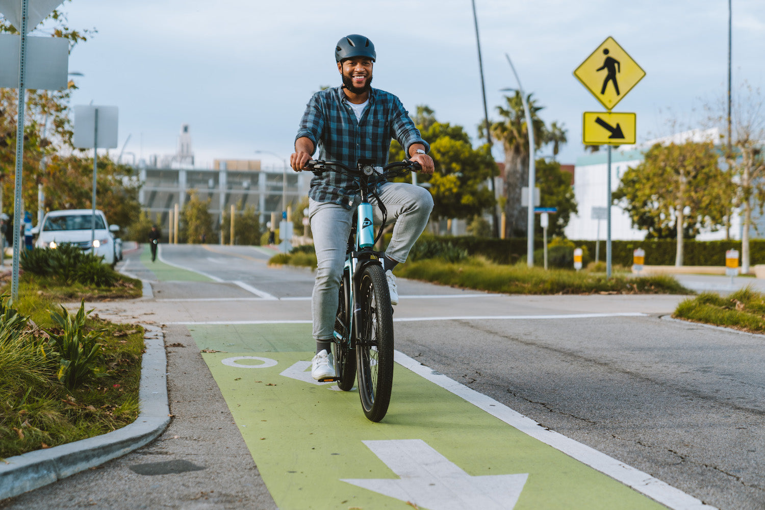 man riding Denago eBike in green bike lane