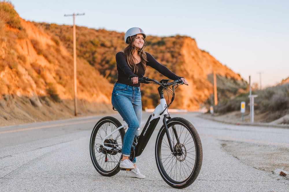 Woman riding a Denago eBike at sunset